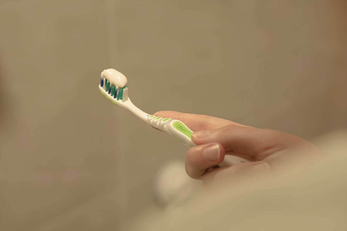 Person holding a soft toothbrush to help prevent bleeding gums