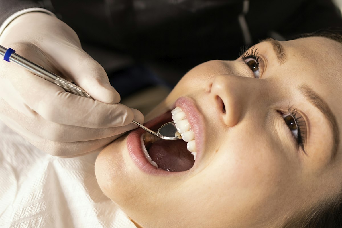 Emergency dentist in Muncie, Indiana examining a patient with a dental mirror